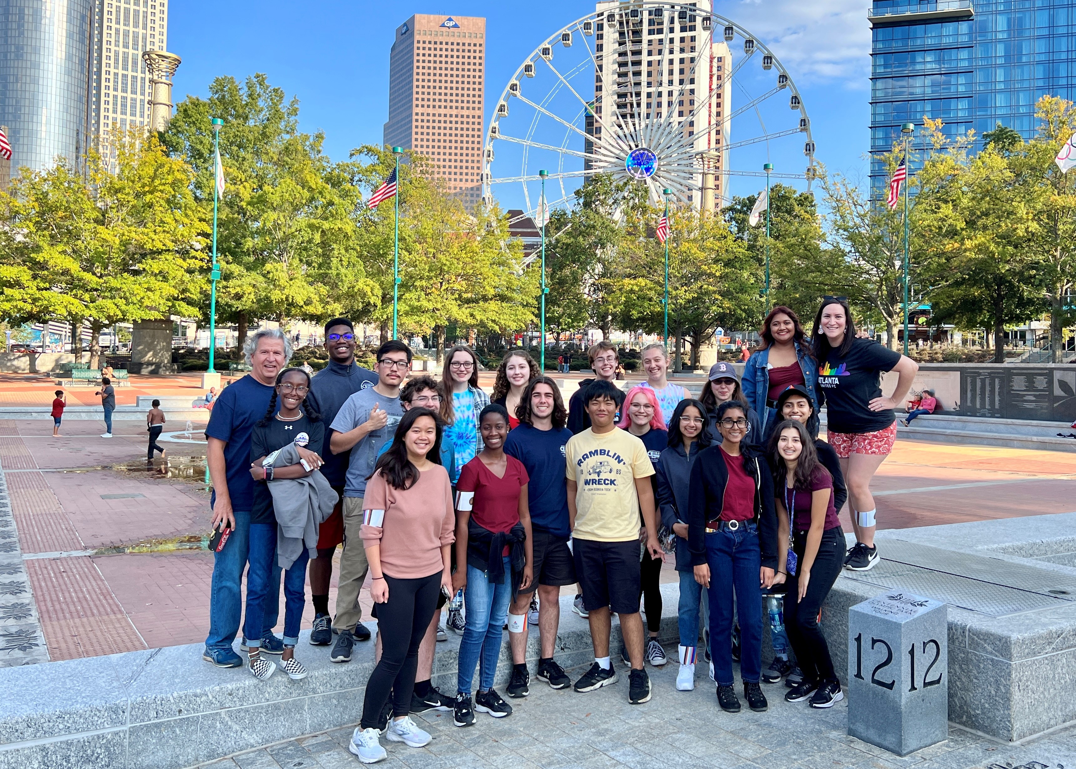 group of college students in front of giant ferris wheel on a sunny day